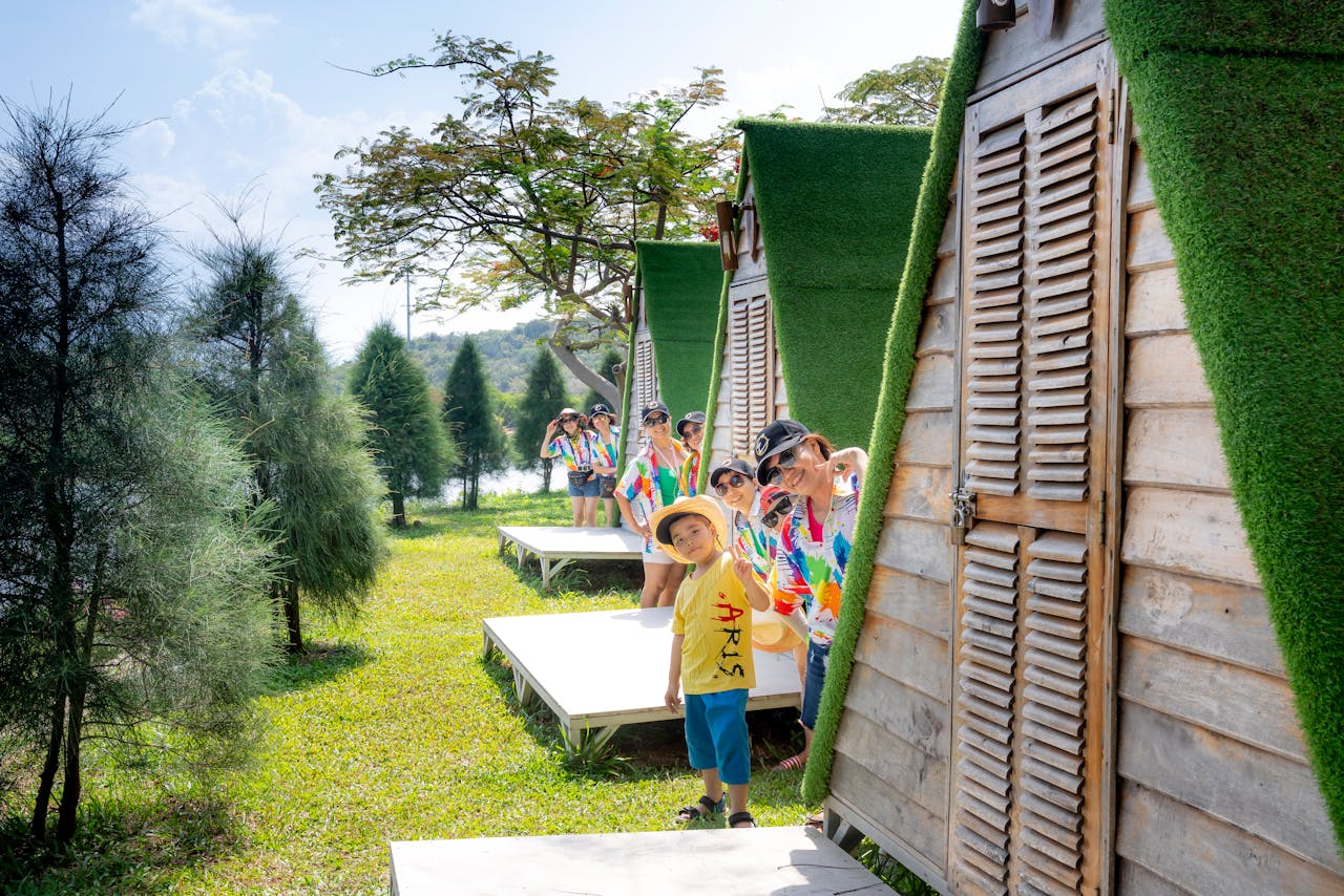 Cheerful family peeking from unique cabin resort outdoors in summer, enjoying nature and each other's company.